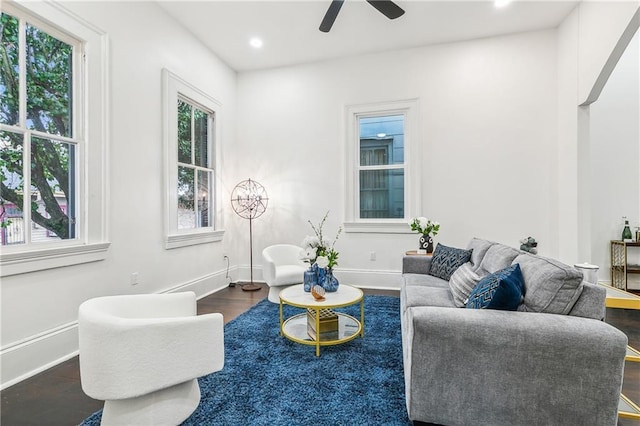 living room with ceiling fan and dark wood-type flooring