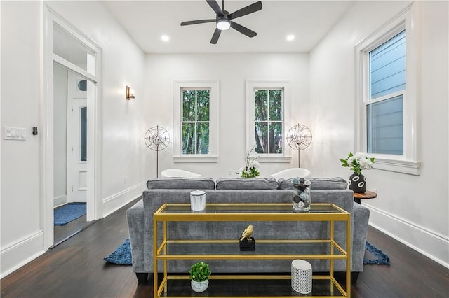 living room with dark hardwood / wood-style flooring and ceiling fan