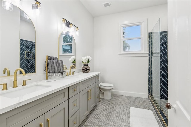 bathroom with tile patterned flooring, vanity, toilet, and a shower