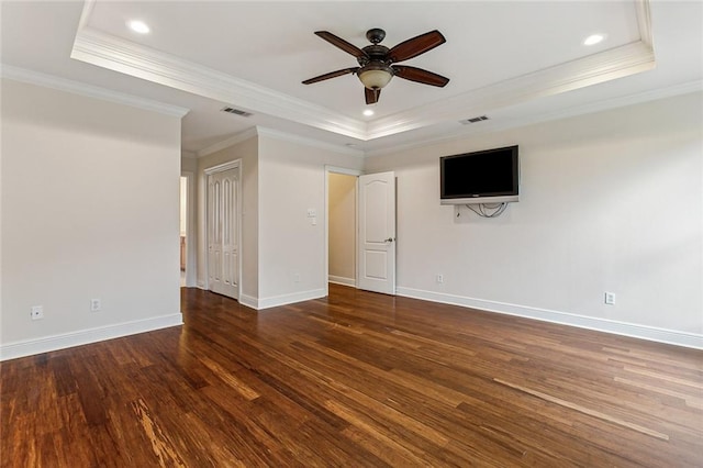 empty room featuring a raised ceiling, ceiling fan, ornamental molding, and hardwood / wood-style flooring