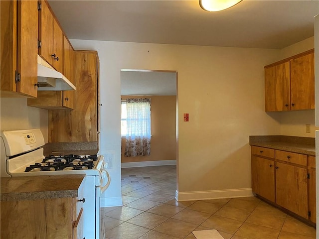 kitchen featuring white gas stove and light tile patterned flooring