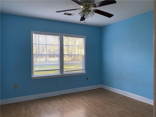 spare room with ceiling fan, hardwood / wood-style floors, and a textured ceiling