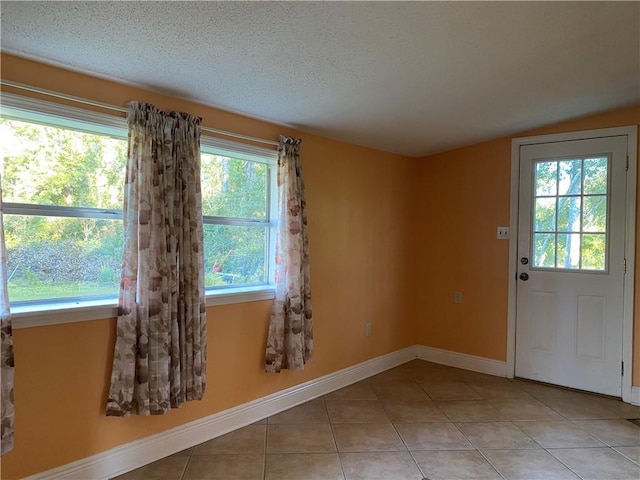 entryway featuring light tile patterned floors and a textured ceiling