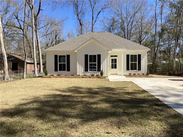 view of front of home with a shingled roof and a front yard