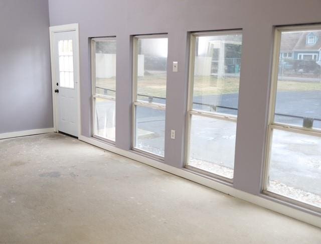 doorway to outside featuring concrete flooring and baseboards