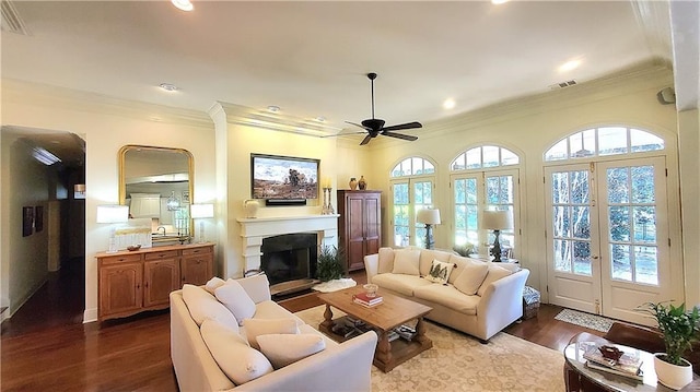 living room featuring ceiling fan, ornamental molding, a healthy amount of sunlight, and hardwood / wood-style flooring