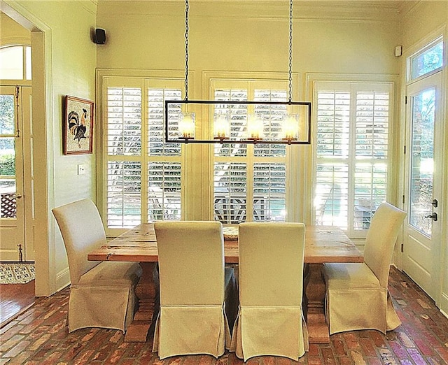 dining area with a notable chandelier, a healthy amount of sunlight, and crown molding