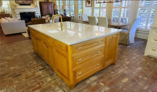 kitchen with a kitchen island with sink, sink, and a wealth of natural light