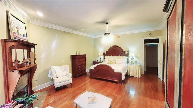 bedroom featuring ceiling fan, wood-type flooring, and crown molding