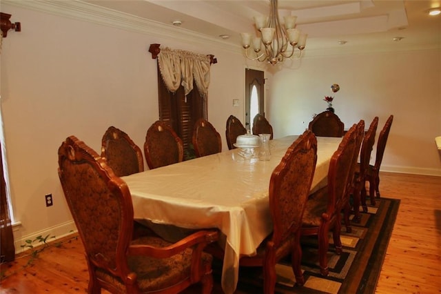 dining room with a chandelier, hardwood / wood-style flooring, and crown molding