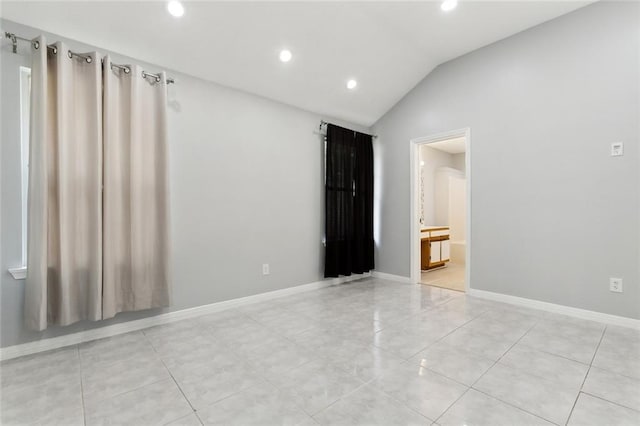 tiled spare room with lofted ceiling