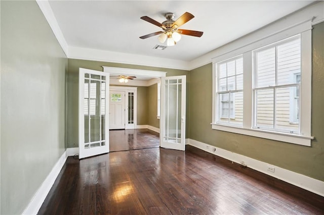 empty room featuring french doors, dark hardwood / wood-style floors, and crown molding