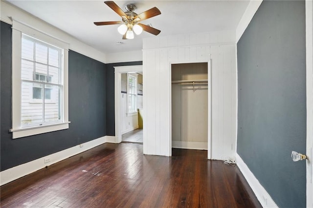 unfurnished bedroom with ceiling fan, a closet, and dark hardwood / wood-style floors