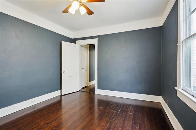 empty room with dark hardwood / wood-style floors, plenty of natural light, and ceiling fan