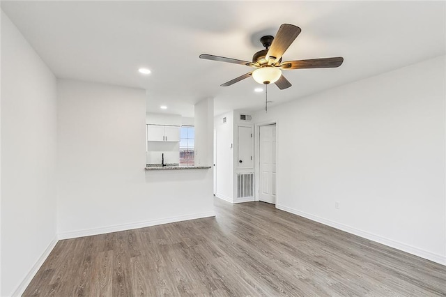 unfurnished living room featuring hardwood / wood-style flooring and ceiling fan