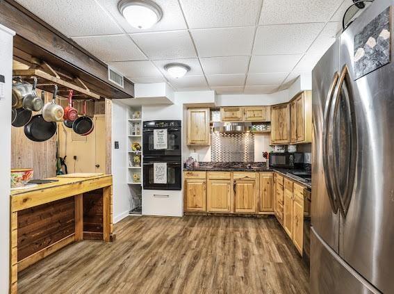 kitchen with dark hardwood / wood-style flooring, a drop ceiling, and black appliances