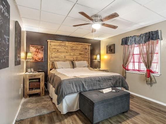 bedroom featuring hardwood / wood-style floors, a paneled ceiling, and ceiling fan