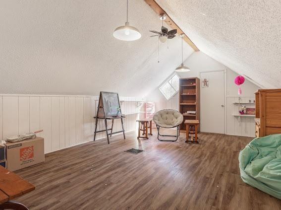 bonus room with dark hardwood / wood-style floors, lofted ceiling, and a textured ceiling