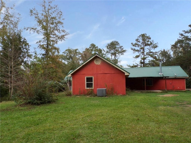 exterior space featuring an outbuilding, a yard, and central AC