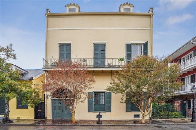 rear view of property with a balcony and stucco siding