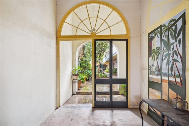 doorway to outside featuring unfinished concrete flooring and french doors