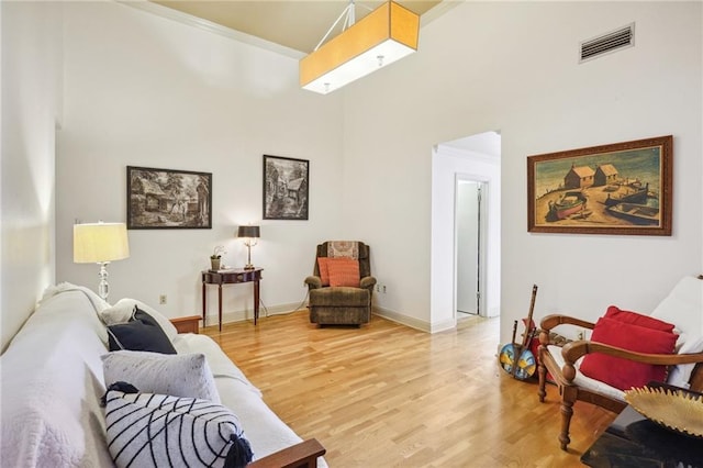 living room with a high ceiling and hardwood / wood-style flooring