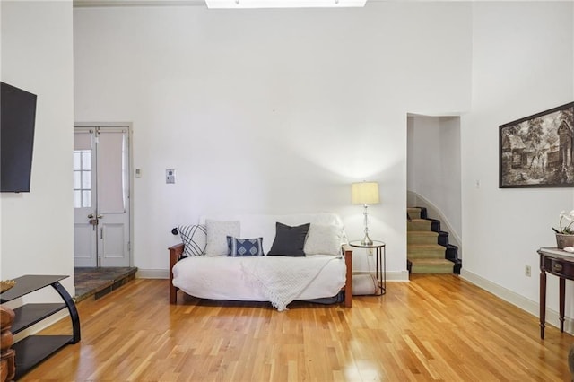 sitting room with wood-type flooring and a high ceiling