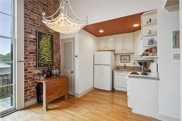 kitchen featuring a notable chandelier, light hardwood / wood-style floors, decorative light fixtures, white appliances, and white cabinets