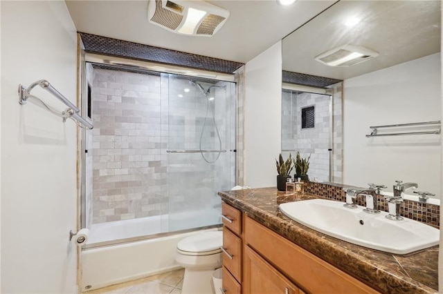 full bathroom featuring shower / bath combination with glass door, tile patterned flooring, vanity, and toilet