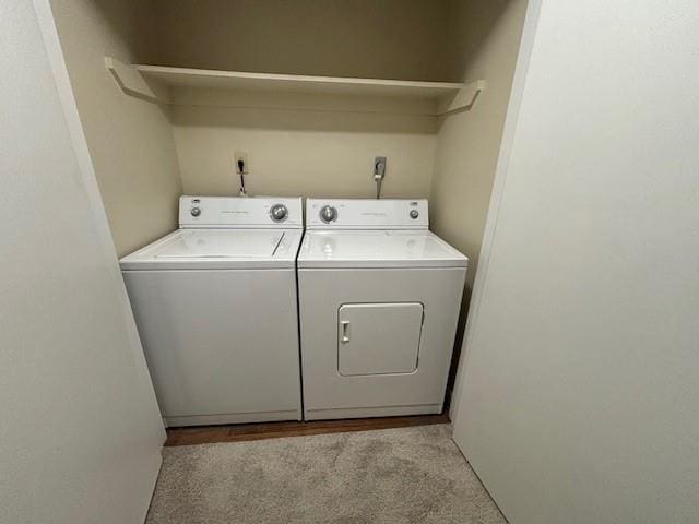 laundry room with washing machine and dryer and light carpet