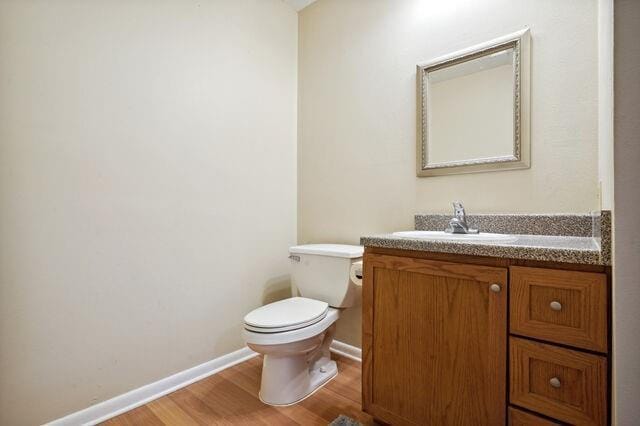 bathroom featuring hardwood / wood-style floors, vanity, and toilet