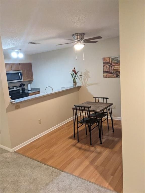 dining room with hardwood / wood-style floors and ceiling fan