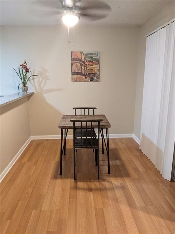 dining area with hardwood / wood-style floors and ceiling fan