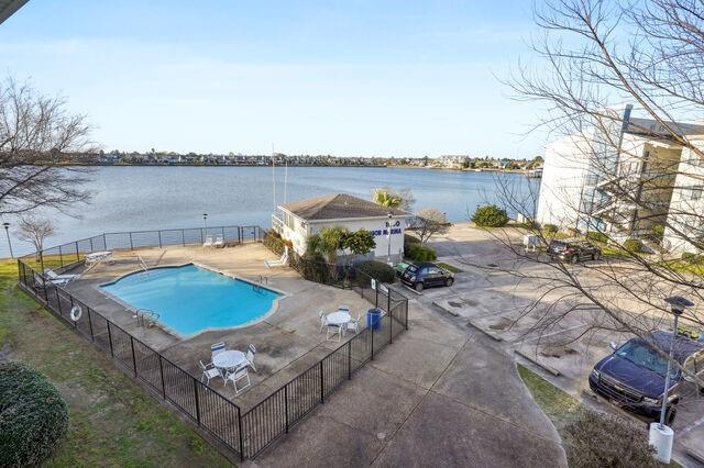 view of pool with a patio area and a water view