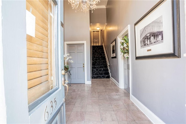 entryway featuring crown molding and an inviting chandelier