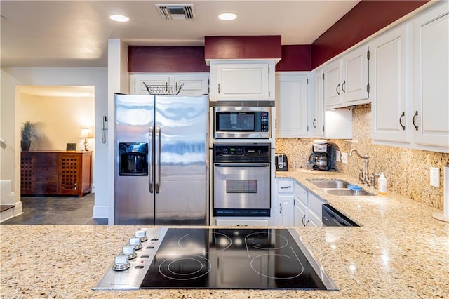 kitchen featuring appliances with stainless steel finishes, white cabinetry, and sink