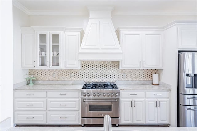 kitchen with white cabinets, light stone countertops, premium range hood, and appliances with stainless steel finishes