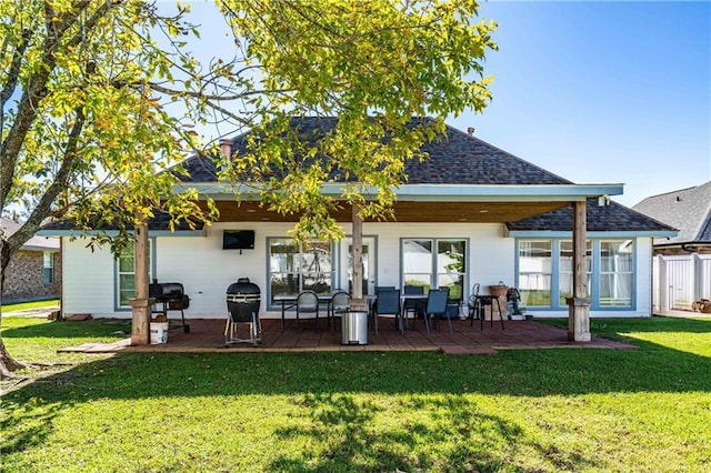 rear view of property featuring a yard and a patio area