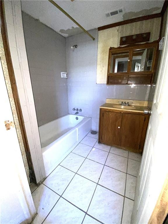 bathroom with tile patterned flooring, vanity, shower / washtub combination, and a textured ceiling