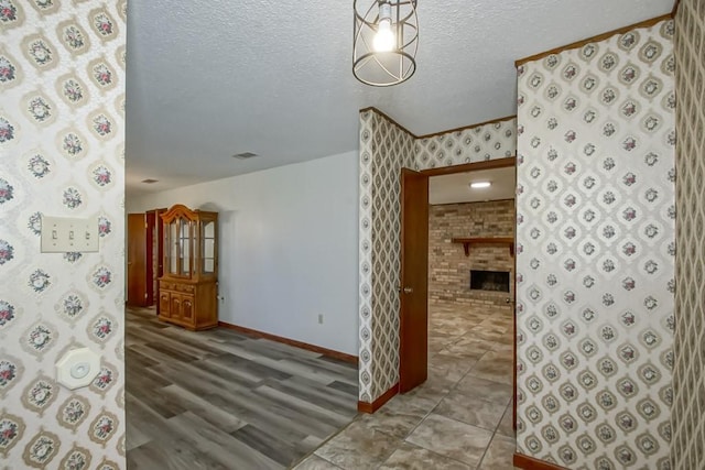 empty room featuring a textured ceiling, a large fireplace, and hardwood / wood-style flooring