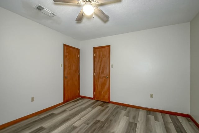 empty room featuring light wood-type flooring and ceiling fan