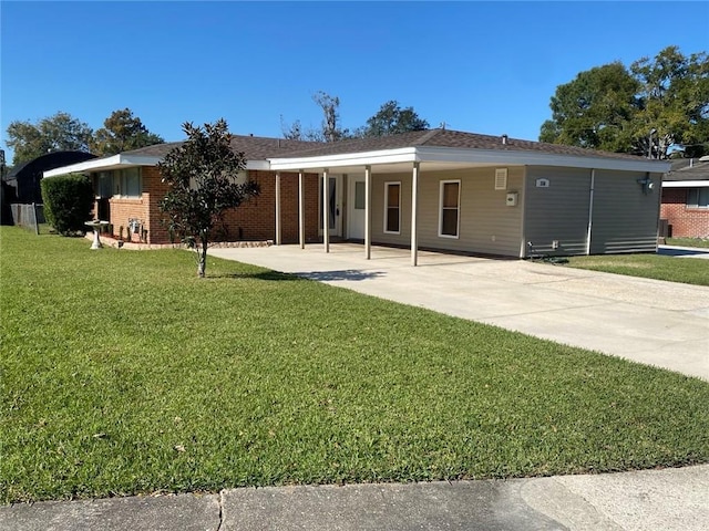 back of property with a carport and a lawn