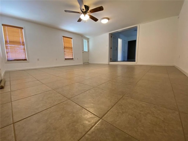 unfurnished room with ceiling fan, light tile patterned floors, and a healthy amount of sunlight