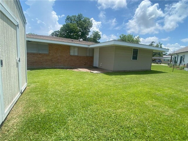 350 Carolyn Dr, Harahan, LA 70123 - rear view of house featuring a lawn and brick siding