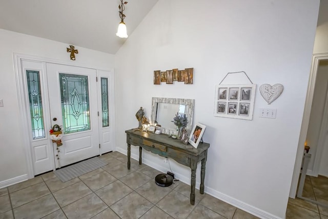 foyer with light tile patterned flooring and high vaulted ceiling