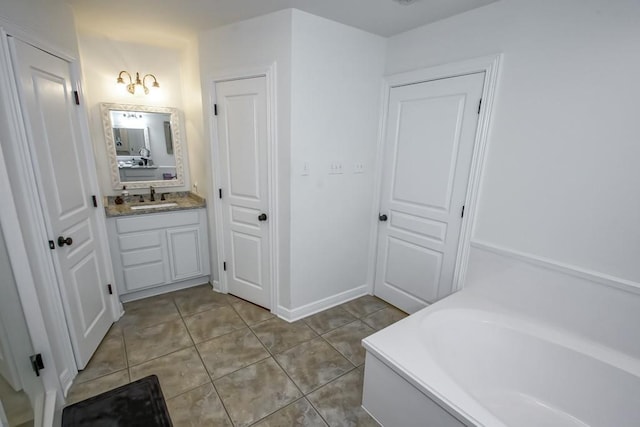 bathroom with tile patterned flooring, a bath, and vanity