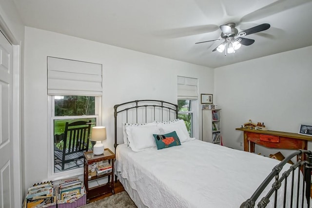 bedroom with hardwood / wood-style flooring, ceiling fan, and multiple windows