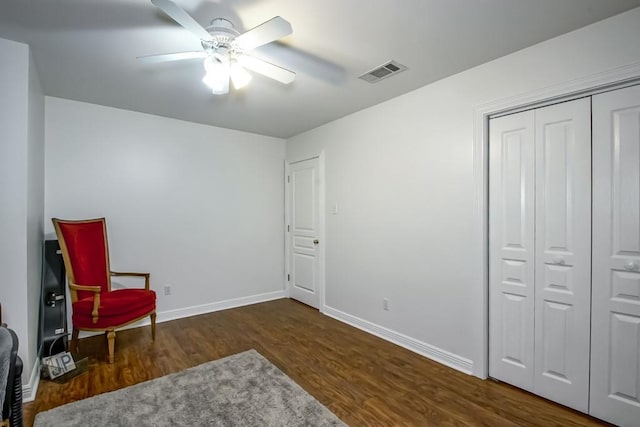 living area featuring ceiling fan and dark wood-type flooring