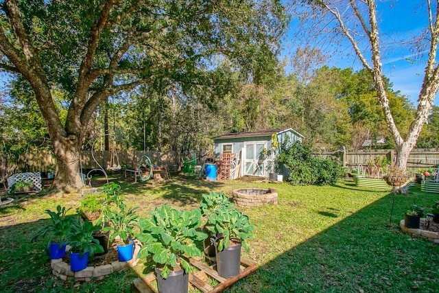 view of yard featuring a shed and an outdoor fire pit