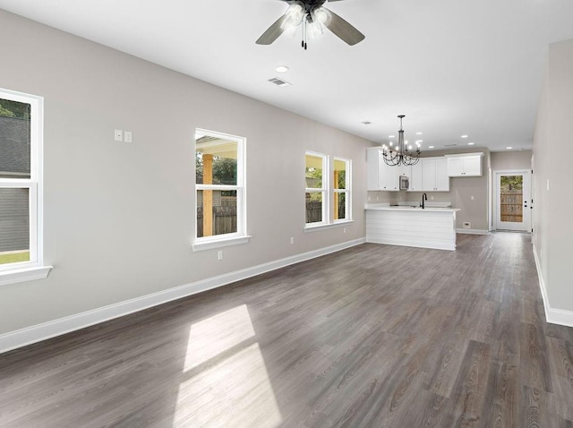 unfurnished living room with ceiling fan with notable chandelier, dark hardwood / wood-style flooring, and sink